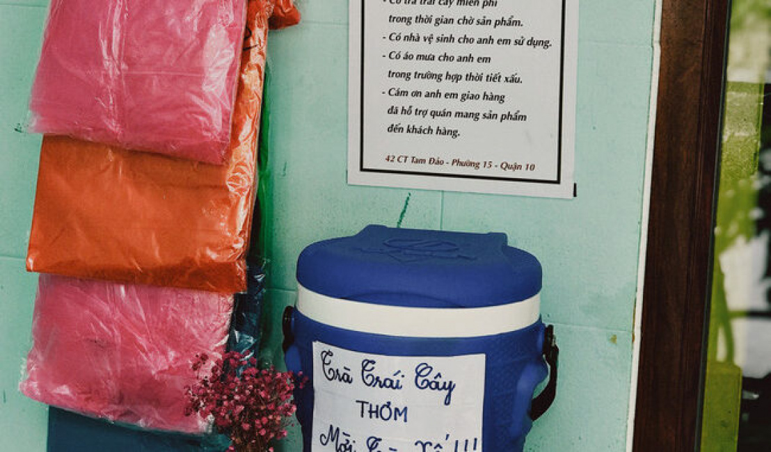 A tea shop in Saigon hangs a sign “share the rain” with shipper: Free fruit tea, free toilet use, raincoat in bad weather