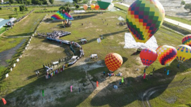 Thousands of tourists watch hot air balloons in the mountain country